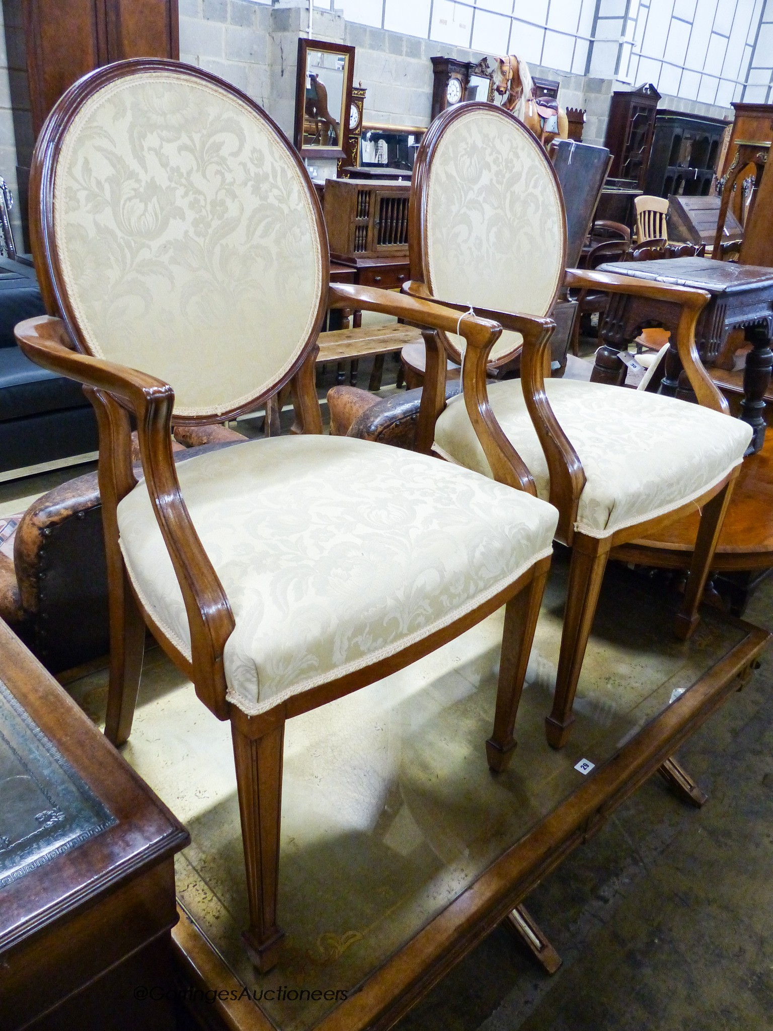 A pair of upholstered elbow chairs, width 57cm, height 100cm